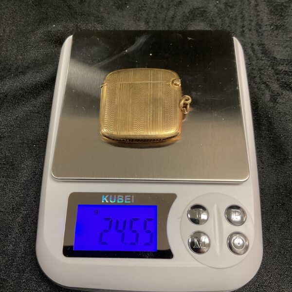 Close-up of vintage 9ct gold Veata compact on a scale.