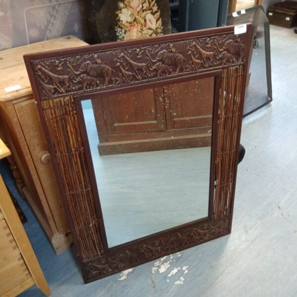 Close-up of the African animal mirror’s carved metal and bamboo frame.