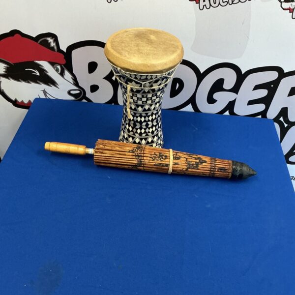 Intricately carved African drum with a parasol top.