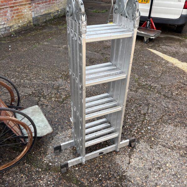 Aluminum multi-position work platform ladder against a brick wall.