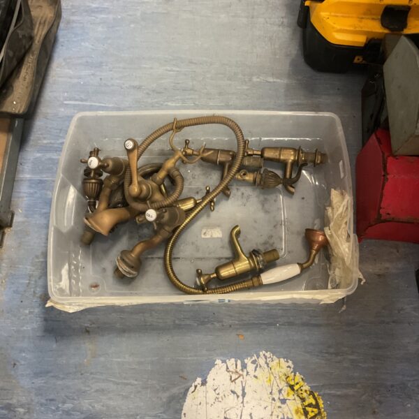 Antique brass bathtub faucet set with porcelain handles.