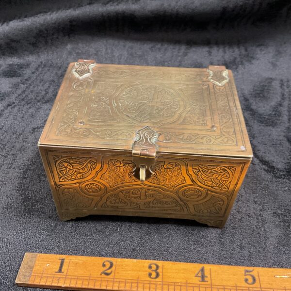 Intricate antique brass casket with engraved patterns.