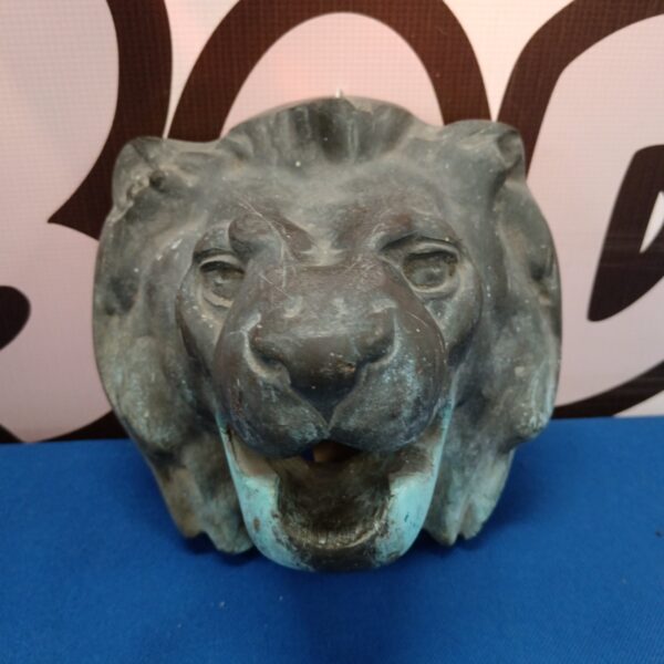 Antique bronze lion head fountain spout with weathered patina.