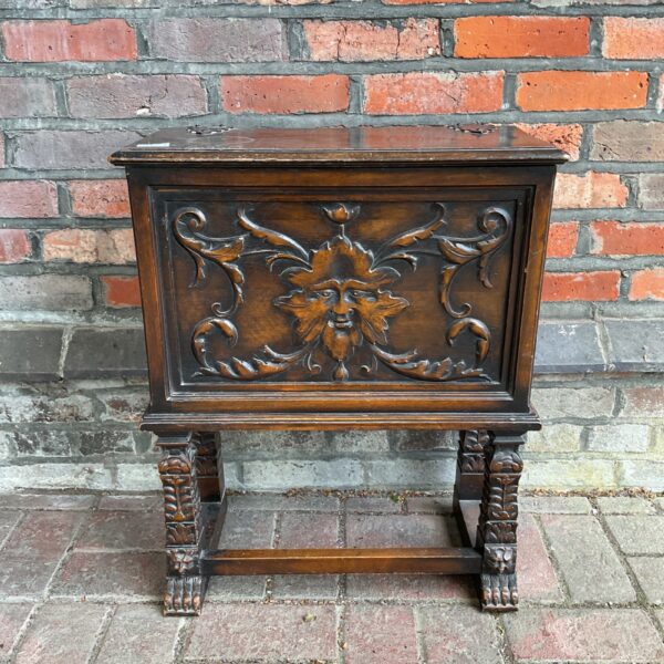 Antique carved chest with Green Man motif and claw feet.