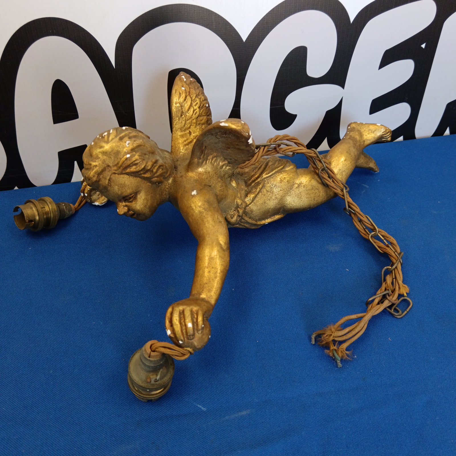 Antique gilt cherub ceiling lamp with detailed sculpting.
