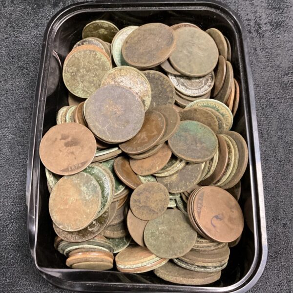 A tub filled with antique copper coins, including Victorian pennies.
