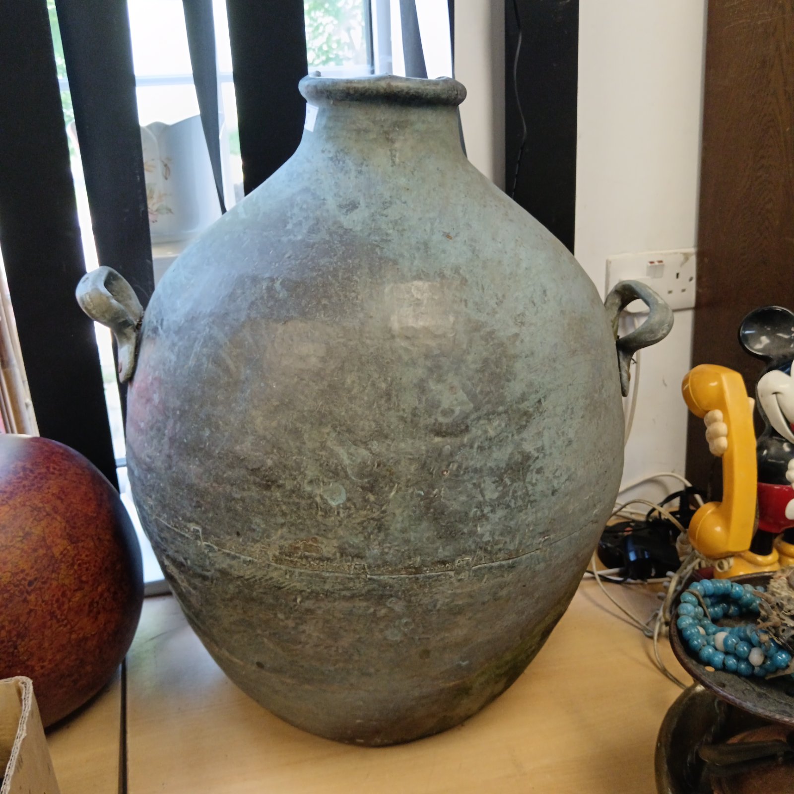 Large antique copper water vessel with patina.