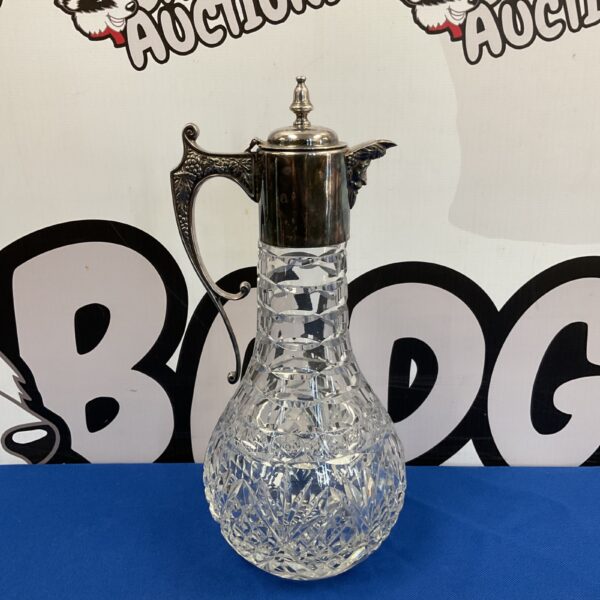 Antique crystal claret jug with silver plate handle and mount.