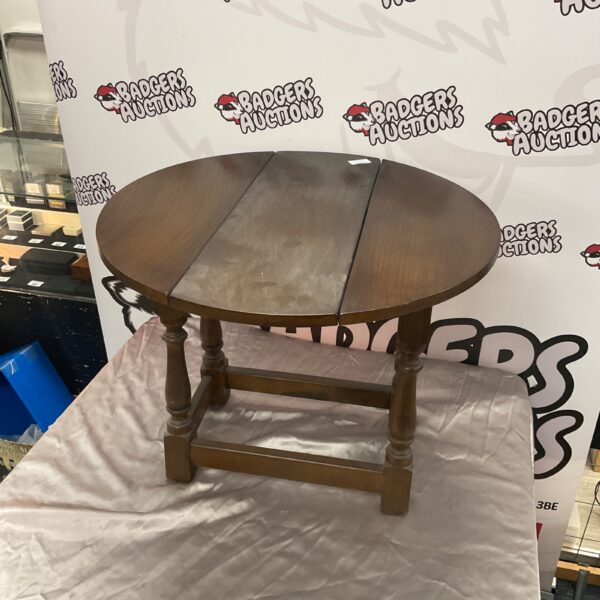 Antique drop leaf side table with twist top and three legs.