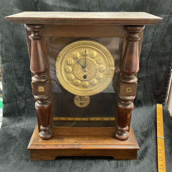 Antique German mantle clock with carved wooden case and Roman numerals.