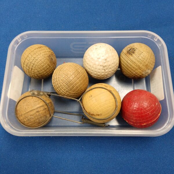 Tray of seven antique gutaperch golf balls for collectors.