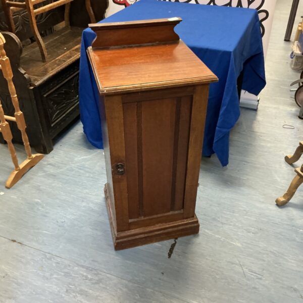 Front view of antique mahogany cabinet with single door.
