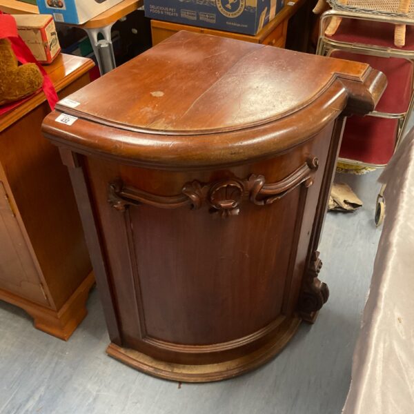 Antique mahogany corner cabinet with detailed carvings and fitted shelves.
