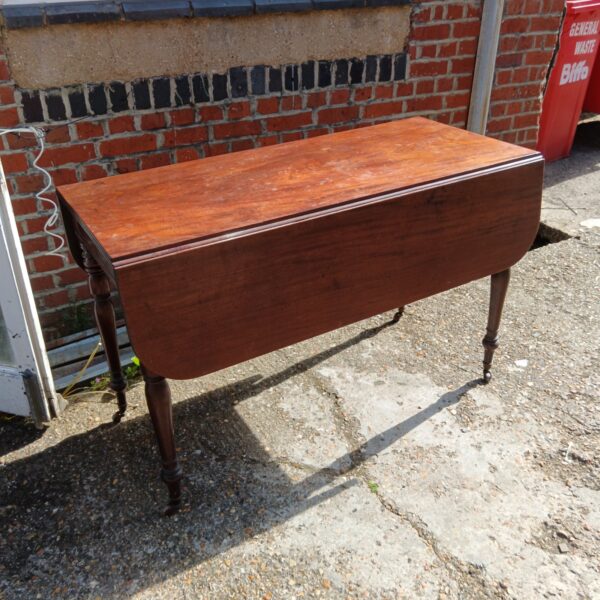 Antique mahogany drop leaf table with drawer, side view.