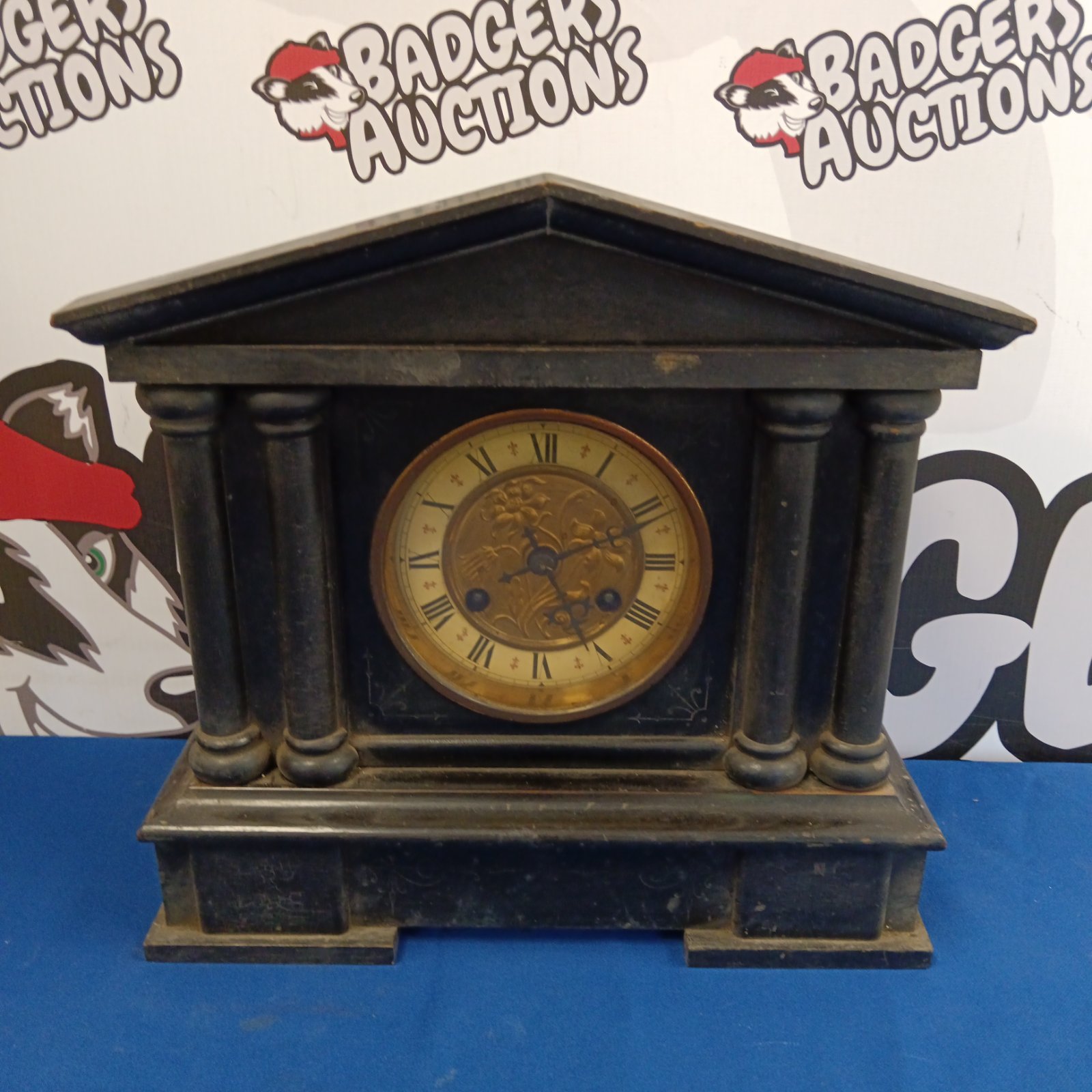Antique wooden mantle clock with visible movement and Roman numerals.