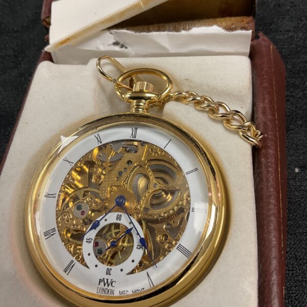 Antique mechanical pocket watch with gold chain and skeleton movement.