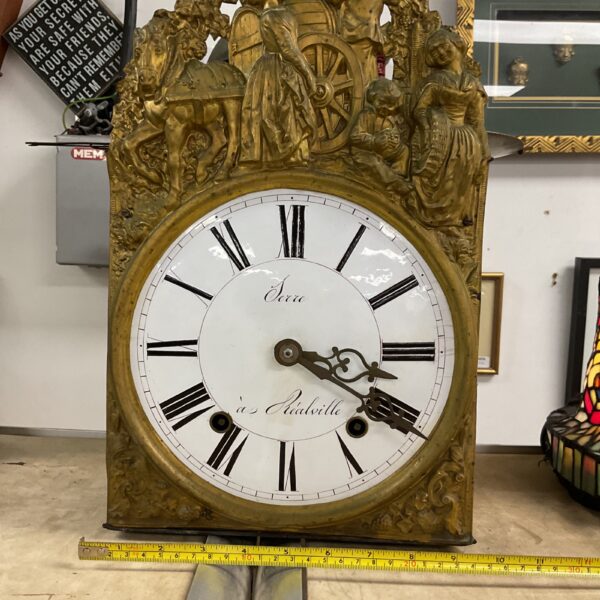 Ornate antique French Morbier Comtoise clock with detailed carvings.