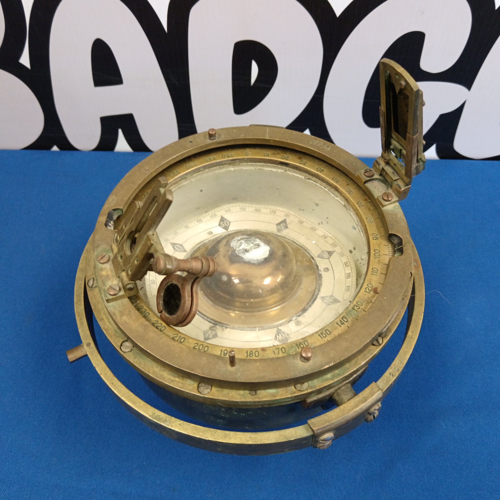 Antique brass ship’s compass with degree markings.