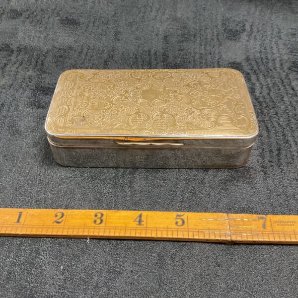 Antique silver gilt trinket box with embossed floral design.