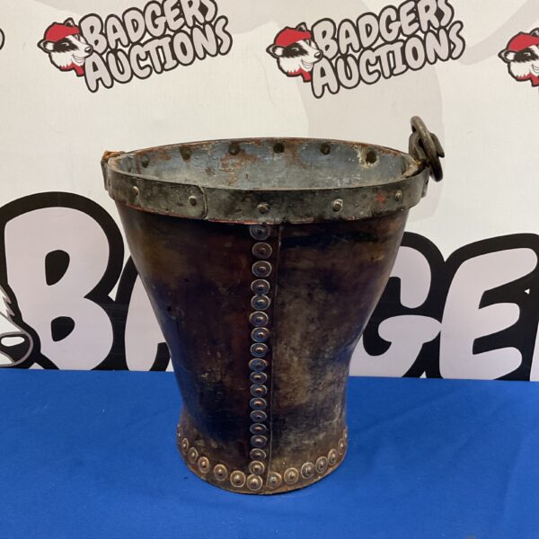 Antique studded leather bucket with metal handle and visible wear.