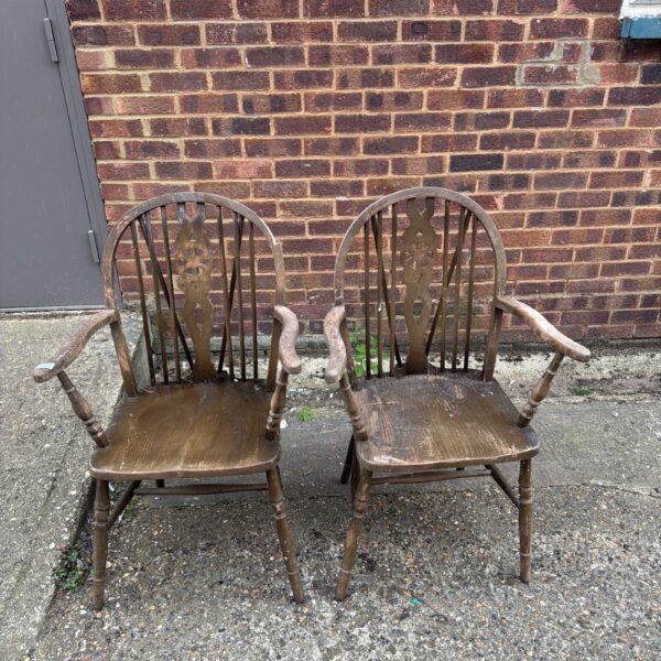 Pair of antique wheelback armchairs awaiting restoration.