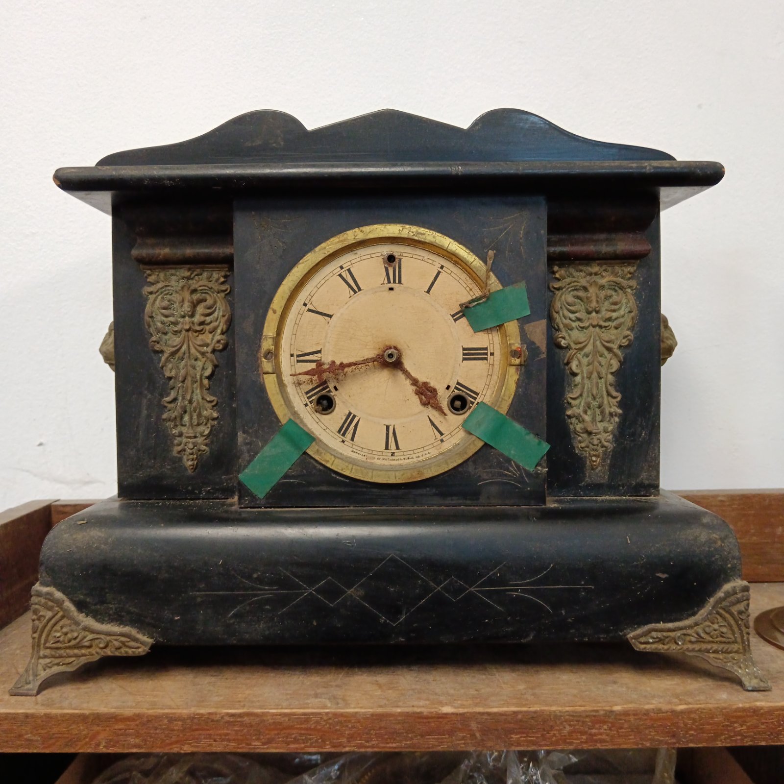 Antique wooden mantle clock with lion head handles, Victorian style.