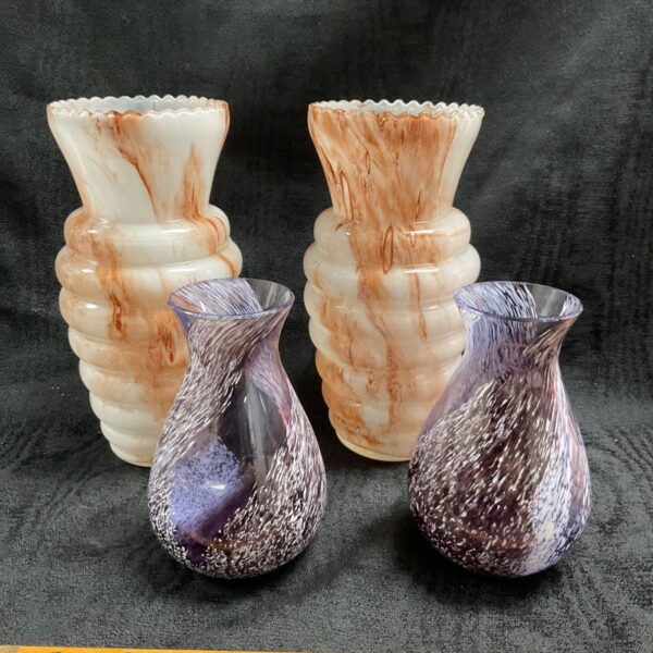 Four purple and cream swirl art glass vases displayed together.