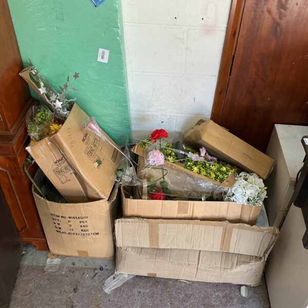 Lot of artificial flowers and foliage in cardboard boxes.