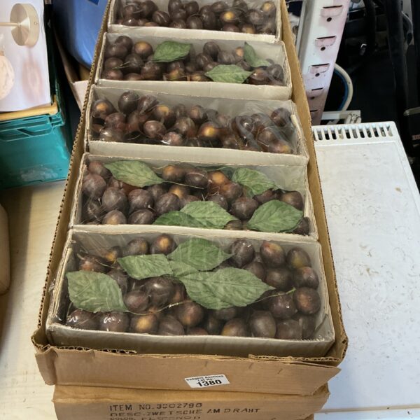 Boxes of dark artificial grapes for display and vintage decor.
