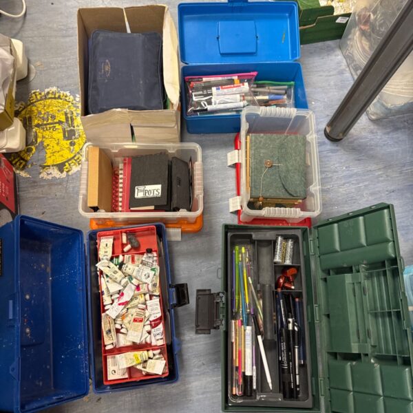 Mixed arts and crafts supplies in plastic storage boxes.