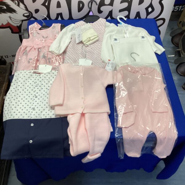 Pink baby clothes bundle with newborn outfits.