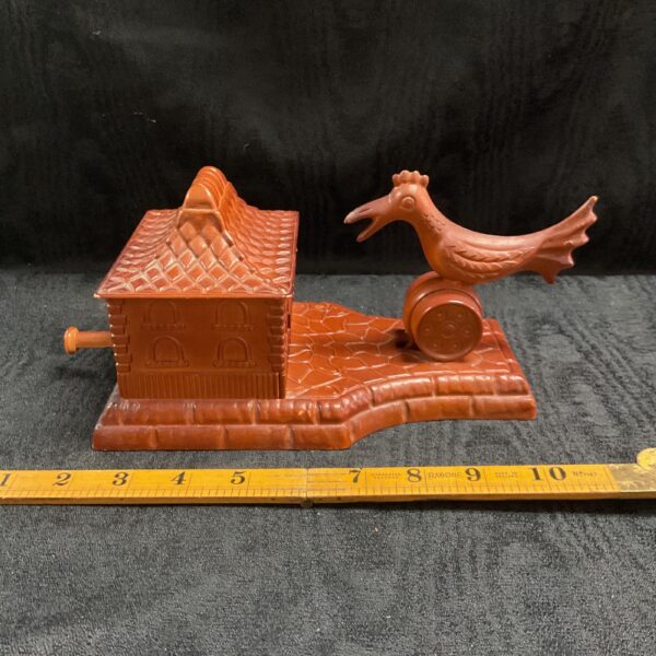 Vintage bakelite cigarette dispenser with bird sculpture.