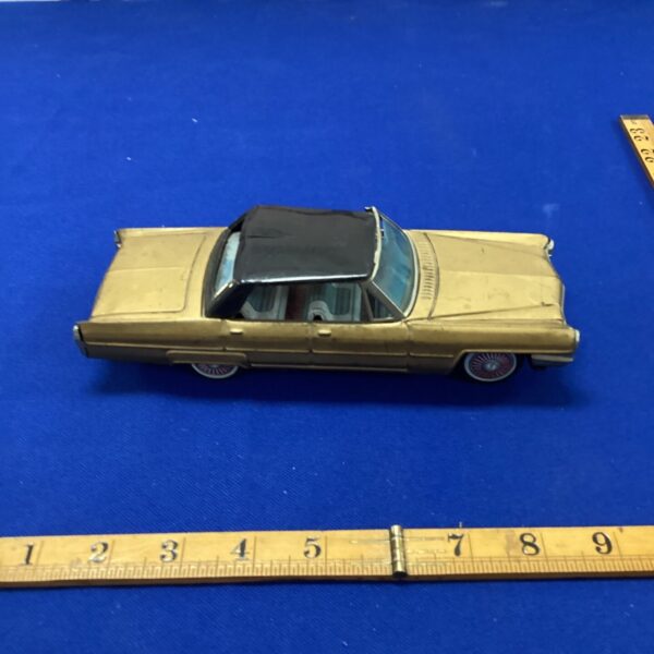 Vintage Bandai Cadillac tin toy car, gold finish, collectible.
