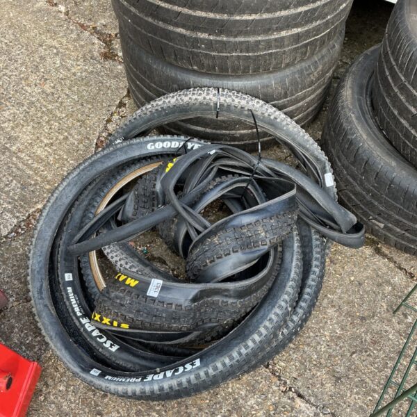 Job lot of used Goodyear bike tyres stacked for sale.