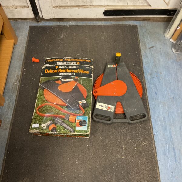 Black and Decker 20 metre reinforced garden hose, coiled and ready for use.