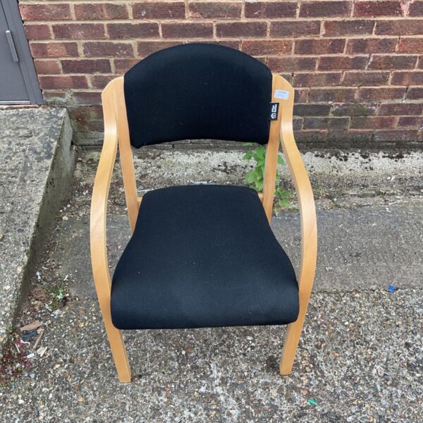 Black office visitor chair with wooden frame, side view.