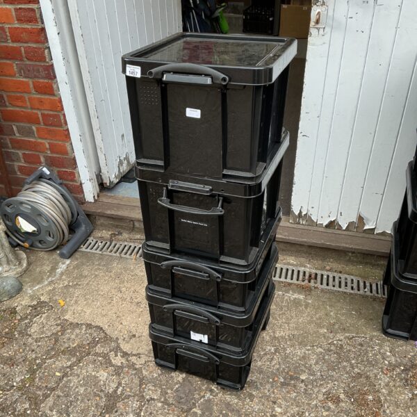 Stack of five black plastic storage boxes for household organisation.