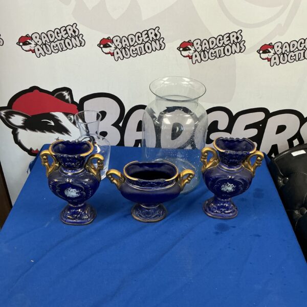 Three blue pottery vases with glass inserts and gold accents.