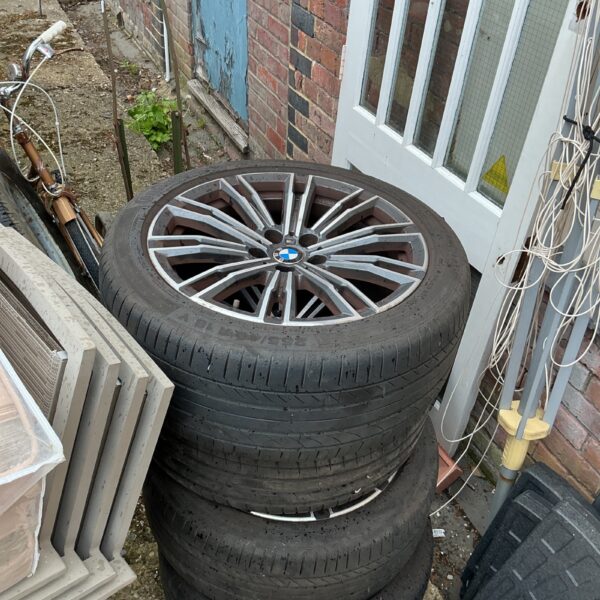 Silver BMW car wheels with tyres, showing signs of wear.