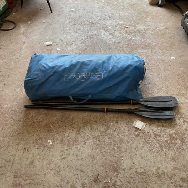 Blue Bombard inflatable dinghy with oars and pump for boating.