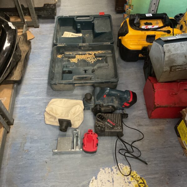 Bosch cordless planer with charger and dust bag in open case.