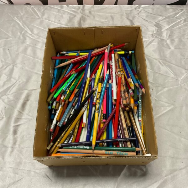 A colourful box filled with a large lot of used pencils.
