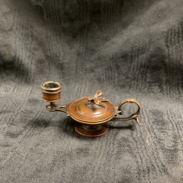 Antique bronze chamberstick with a detailed dragonfly design.