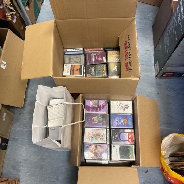 Mixed lot of vintage cassette tapes in boxes and a bag.