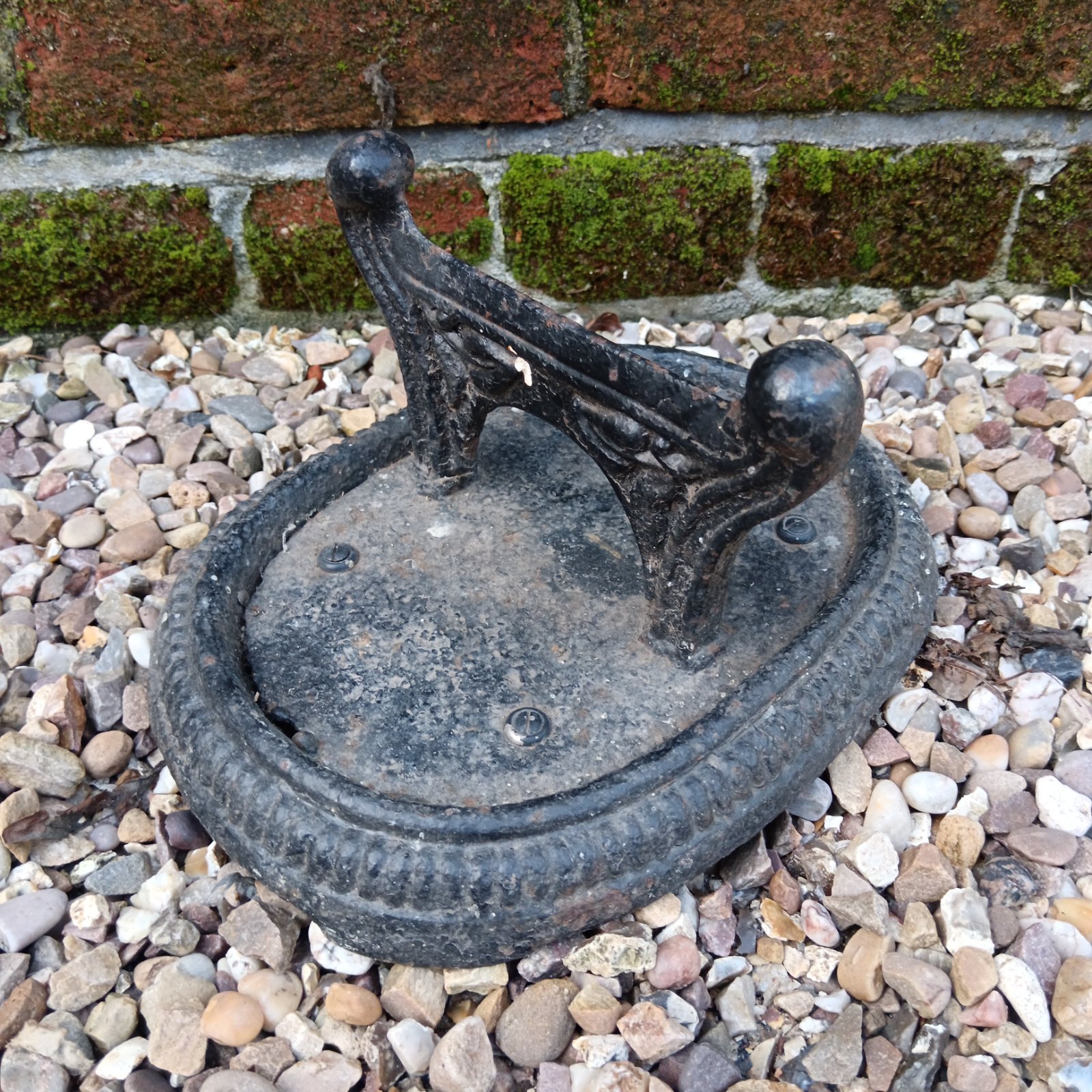 Antique cast iron boot scraper with floral design.