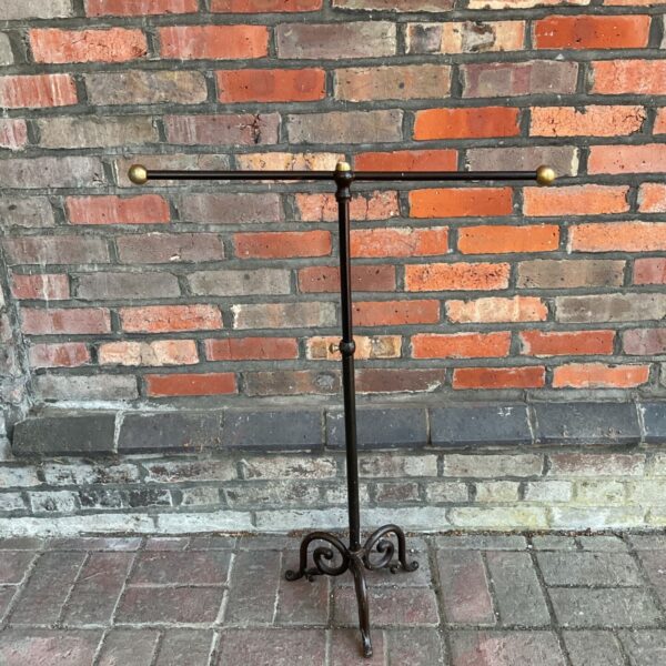 Antique cast iron towel rail with brass details for bathroom decor.