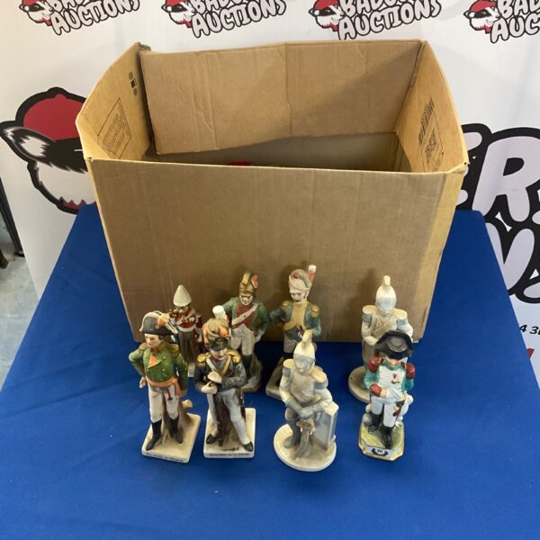 Collection of vintage ceramic soldier ornaments in a cardboard box.