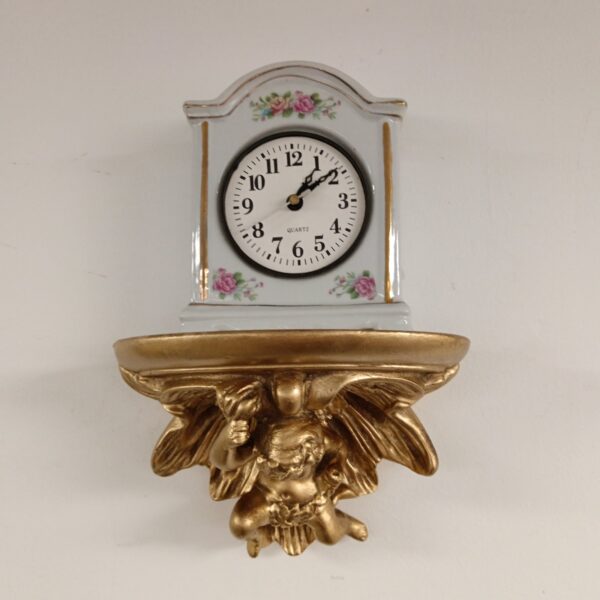 Gilded cherub wall clock with ceramic face, vintage style.