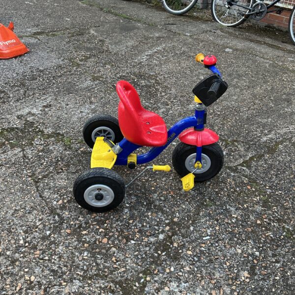 Bright red, yellow and blue child’s tricycle for outdoor play.