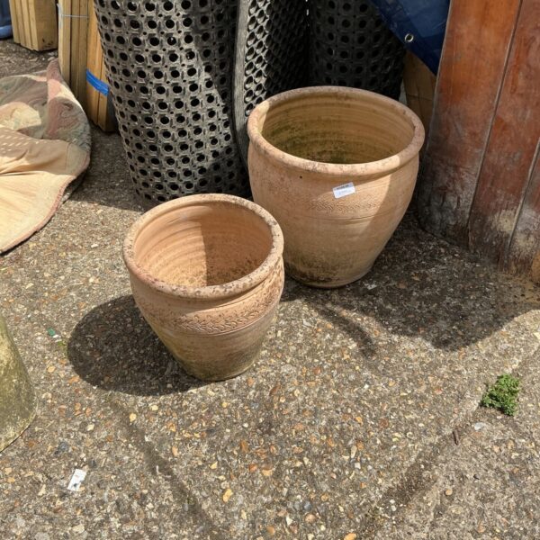 Pair of weathered terracotta clay garden pots for garden planting.